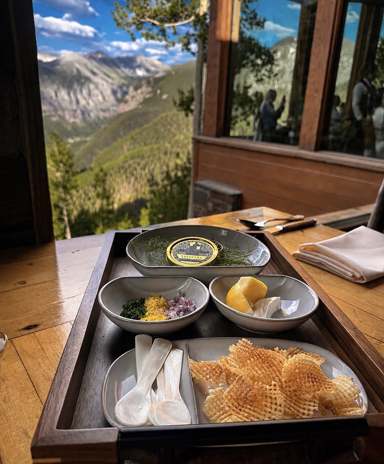 A tableside caviar service tray with traditional accompaniments, overlooking the San Juan Mountains from Allred's