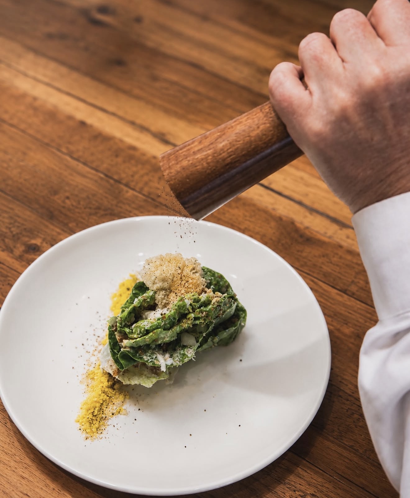 A chef plating seared beef over farro at Allred's